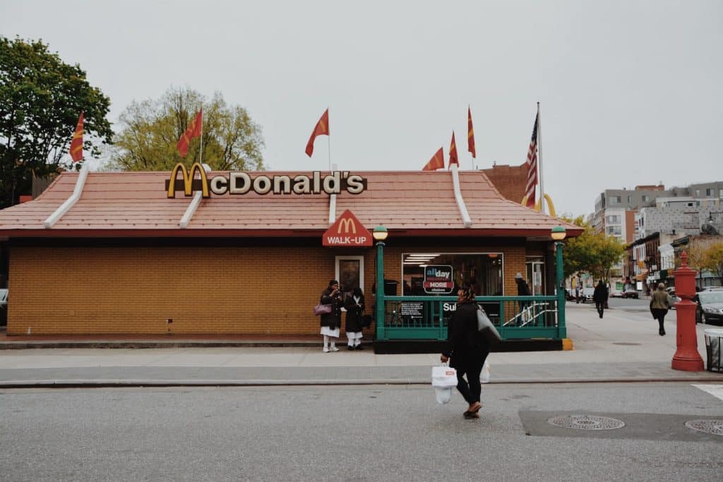 woman walking towards McDonald's branch during daytime