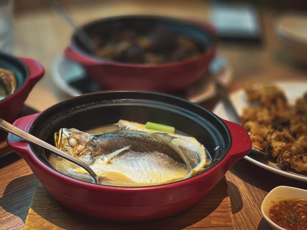 black and red ceramic bowl with food on brown wooden table