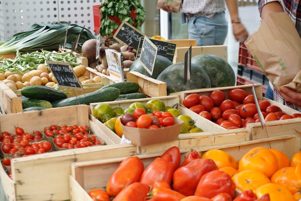 red and green bell peppers on white plastic crate